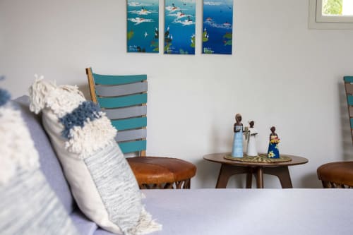Chambre côtière à Cote Et Dune avec fauteuils turquoise, figurines africaines décoratives et œuvres nautiques