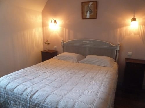 Acogedora habitación en el Château De Clusors B&B en Saint-Menoux con iluminación cálida, cama queen y decoración elegante