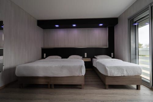 Habitació triple moderna a l'Hôtel Rocade Pamiers amb dos llits de fusta, capçal negre, il·luminació LED i vistes a la ciutat