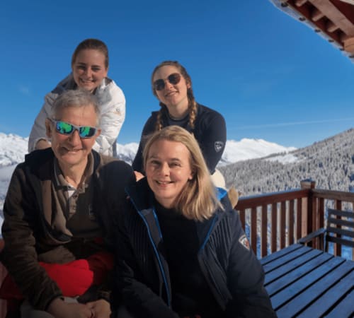 The family owners of CosyArc welcoming you in front of their snow-covered holiday rentals in Les Arcs"