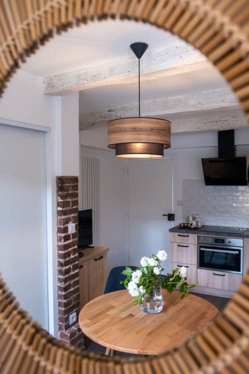 Coin repas moderne à la Chambre d'hôtes Le Pignié avec table en bois, luminaire suspendu et électroménagers inox
