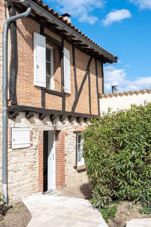 Façade historique en pierre et colombages de la maison d'hôtes Le Pignié à Lescure-d'Albigeois, vue sur le jardin