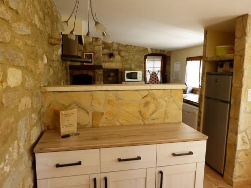 Rustic stone kitchen with wooden counter and white cabinetry at Villa Thébaïde B&B, Laudun L'Ardoise