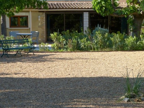 Villa Thébaïde terrace with gravel courtyard, blue seating, Mediterranean plants, Laudun L'Ardoise