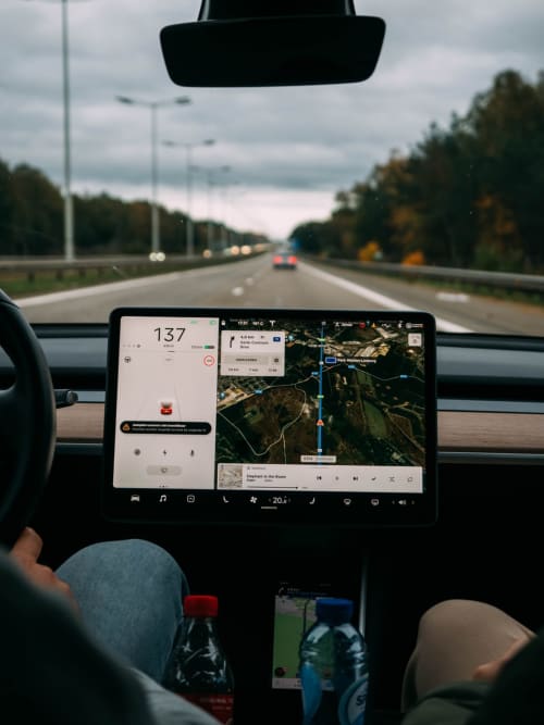 Tableau de bord Tesla affichant la navigation et la vitesse sur l'autoroute près d'Orvault, France