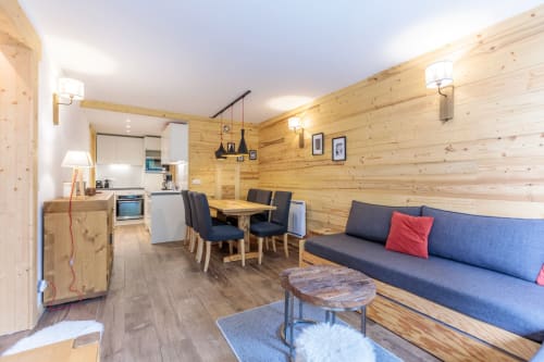 Appartement moderne en bois à Cosyarc aux ARCS  avec cuisine équipée, salle à manger et canapé bleu aux coussins rouges