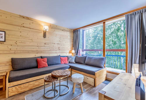 Salon moderne en bois avec canapé en L et vue sur la forêt depuis le balcon à Arc 1800, Bourg-Saint-Maurice