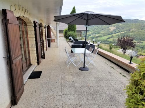 Terrasse avec table de jardin et parasol, vue sur la montagne, Boëge. 