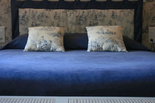 Blue bed with decorative toile pillows in Alexandre Apartment at La Chatellenie, Saint Aubin le Cauf