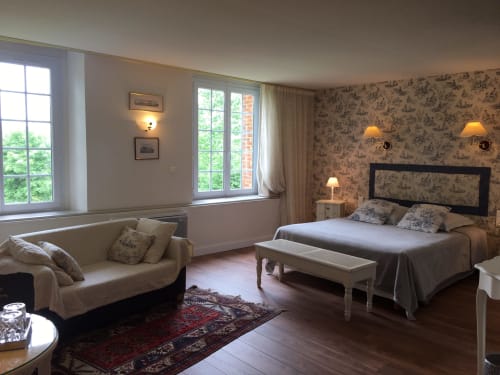Spacious apartment bedroom at La Chatellenie, Saint Aubin le Cauf, with queen bed, sofa, large windows, and classic French