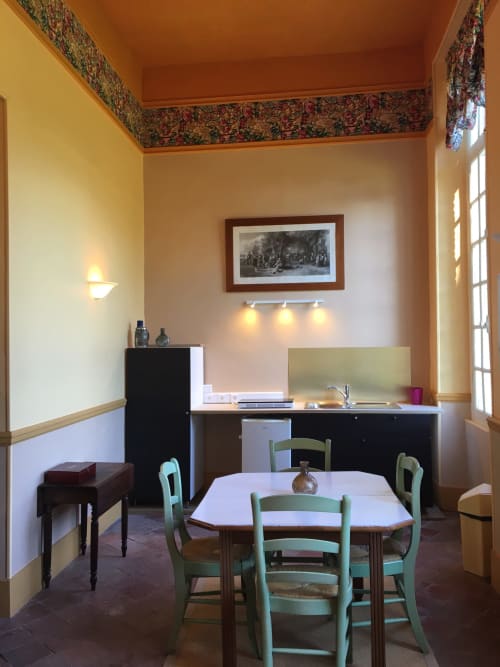 La Chatellenie apartment dining room with green chairs, work desk, and period décor in Saint Aubin le Cauf