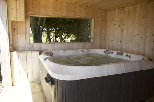 Hot tub in wooden cabin at Espace Ker Gana bed and breakfast, Plourin France with forest view