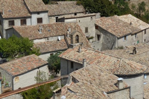 Vue aérienne du gîte Entre Terre Et Ciel à Rémuzat, France, avec ses bâtisses en pierre aux toits de tuiles