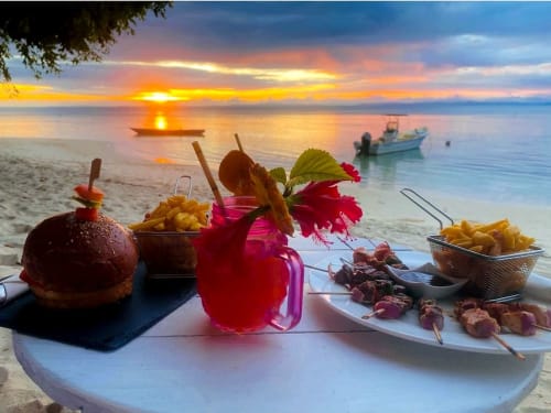 hamburger frites brochettes au coucher du soleil sur plage 