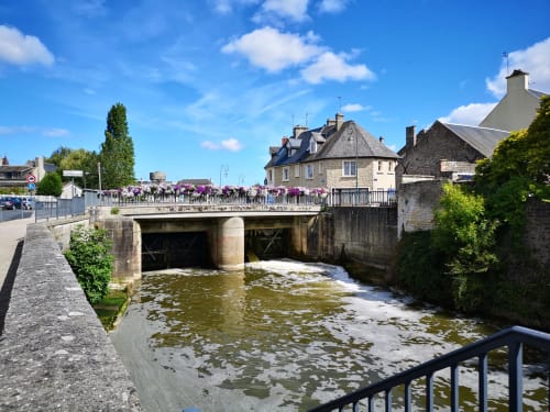 Bridge over tidal river with stone houses and crowds at Isigny-sur-Mer, France near Au Gite d'Isigny BnB