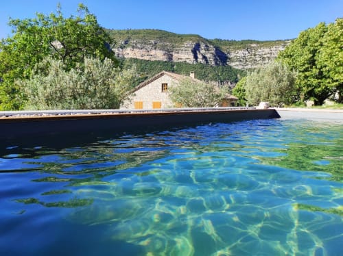 Piscine cristalline à Entre Terre Et Ciel à Rémuzat, avec maison en pierre et falaises