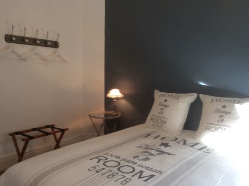 Chambre élégante de la Villa 13 à Mers-les-Bains avec parure de lit thème 'Home', lampe de chevet, patères murales et décoration moderne