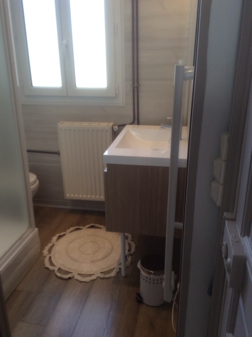 Salle de bains moderne de la Villa 13 à Mers-les-Bains avec lavabo, toilettes, radiateur de chauffage et douche