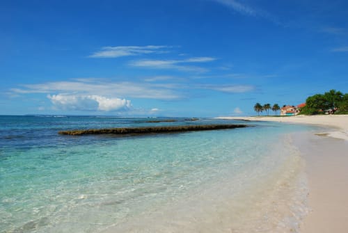 Plage de sable blanc immaculée à Studio Face Marina à Saint-François, avec ses eaux turquoise cristallines et ses palmiers