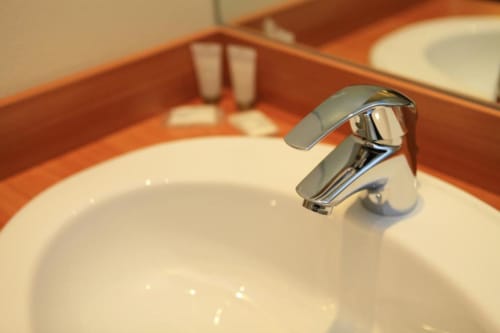 Modern chrome faucet at La Consigne hotel sink in Caen, France double room bathroom