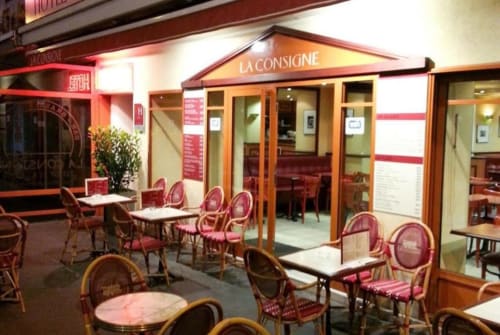Hotel café La Consigne en Caen con sillas rosas, mesas de madera y zona de estar con interior moderno