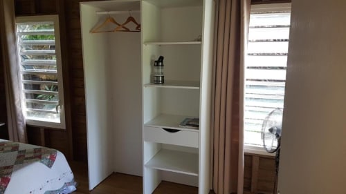 White wardrobe with hangers and storage shelves in Le Bougainvillier Blanc bungalow, Pointe Noire