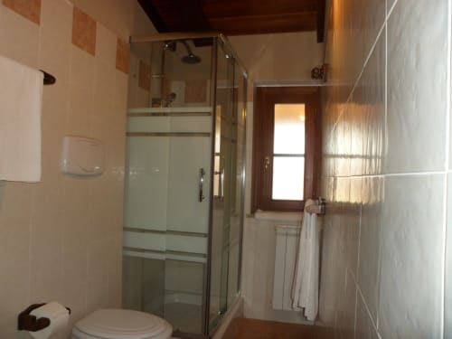 Bagno moderno a Podere Oca Bianca con doccia in vetro, WC e scaldasalviette riscaldato