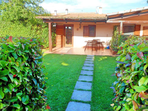 Camera Camelia con vista giardino a Podere Oca Bianca, terrazza, prato, siepi e zona pranzo a Pescia Romana