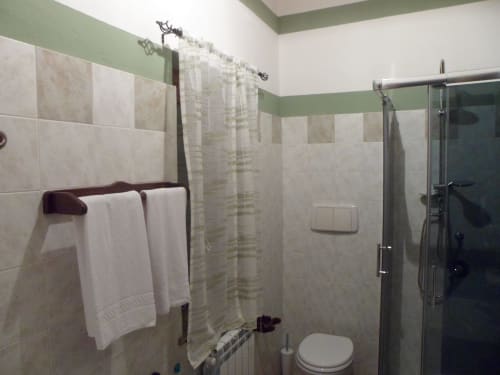 Bagno moderno nella camera Begonia di Podere Oca Bianca con doccia, toilette e porta asciugamani