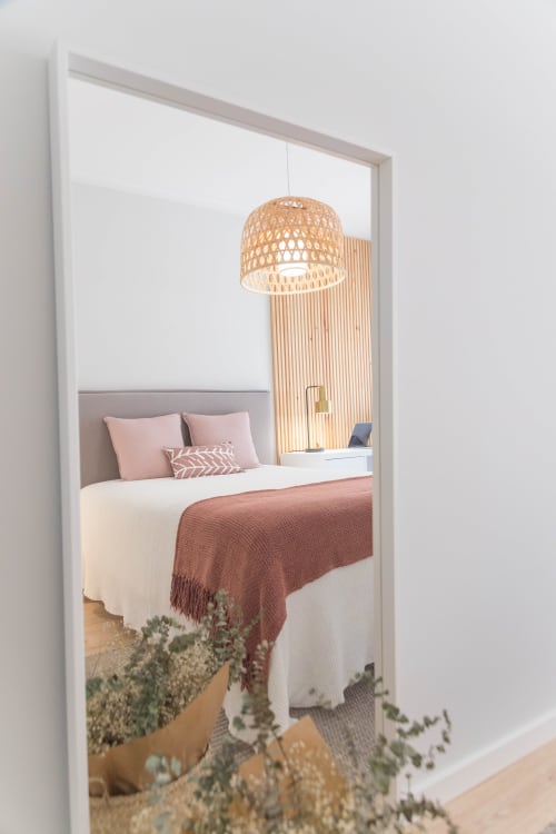 Junior Suite Rose bedroom with pink bedding, woven pendant lamp, and wooden accent wall at French Riviera House, Menton