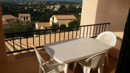Terrasse avec table à manger surplombant un village corse et le paysage méditerranéen