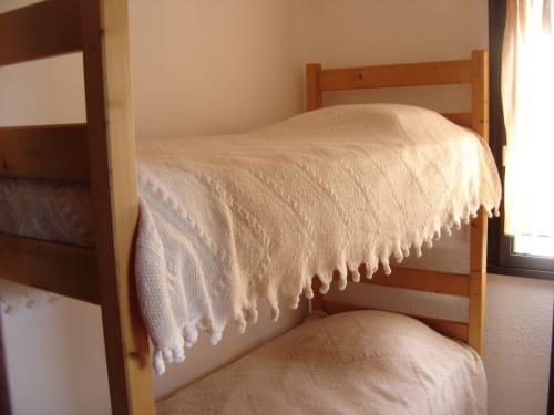 Lits superposés avec parure de lit crème dans l'appartement de Porticcio, location de vacances en Corse avec vue sur mer