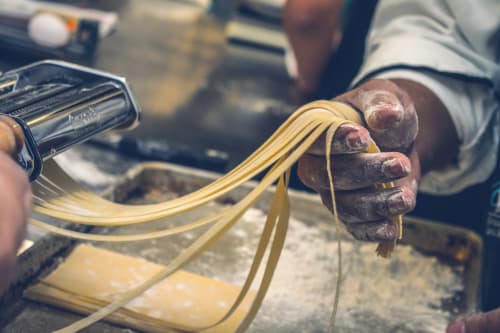 Fresh pasta being made by hand at French Riviera House in Menton, showing strands of linguine from a pasta maker