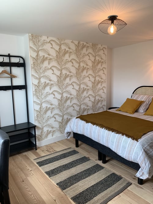 Modern bedroom at Les Remparts De Joussaume Latour in Château-Thierry with bed, botanical wallpaper, and contemporary ceiling