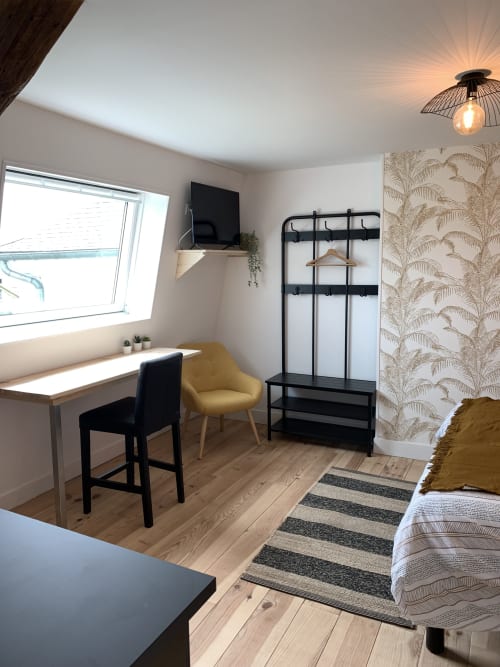 Modern studio apartment at Les Remparts de Joussaume, Château-Thierry with desk, TV, bed, and garden view