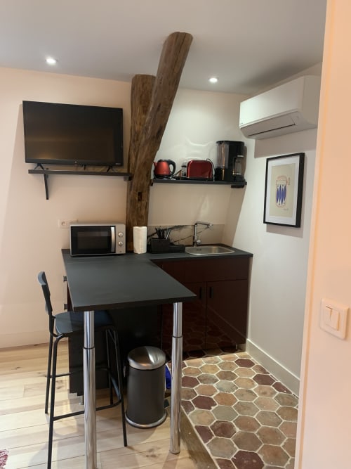 Compact kitchenette in Le Rat des villes apartment at Les Remparts De Joussaume, Château-Thierry with TV, microwave, sink and
