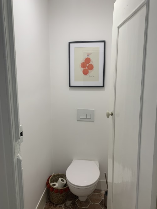 Modern bathroom in Les Remparts De Joussaume Latour, Château-Thierry with white toilet, framed fruit artwork, and decorative