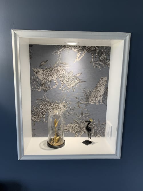 Framed wallpaper display with leopard print design, decorative vase, and bird figurine in Suite Le Héron at Les Remparts De