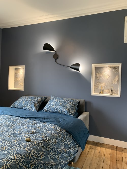Modern bedroom at Les Remparts De Joussaume Latour in Château-Thierry with blue patterned bedding, dark accent wall, and