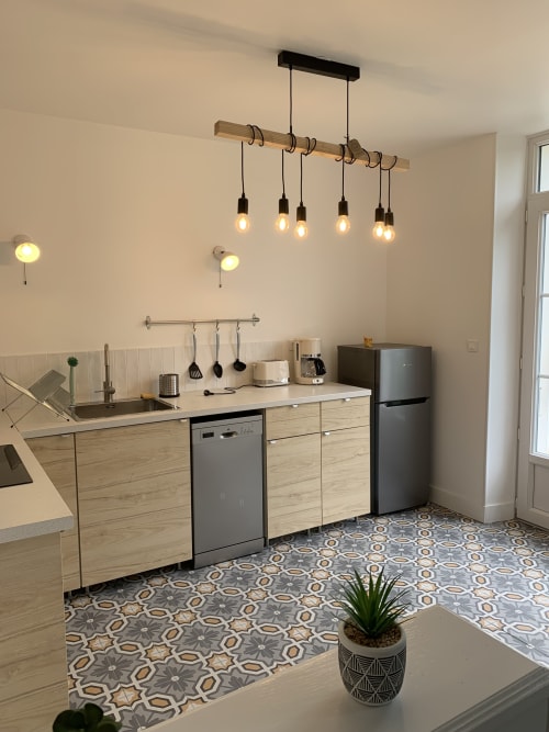 Modern kitchen in Suite Le Renard et les raisins at Les Remparts De Joussaume, Château-Thierry, with wooden cabinetry and