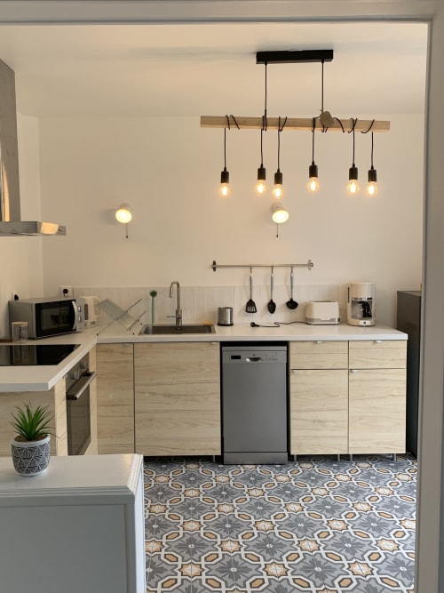 Modern kitchen in Suite Le Renard et les raisins at Les Remparts De Joussaume, Château-Thierry with pendant lighting and