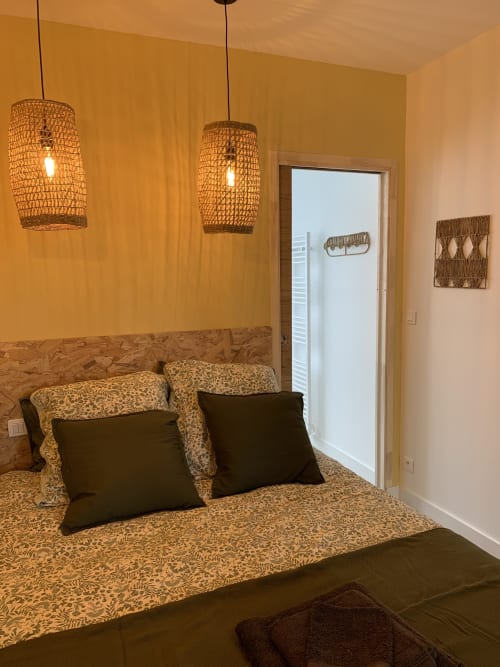 Cozy bedroom at Les Remparts De Joussaume Latour B&B in Château-Thierry with woven pendant lights and patterned bedding
