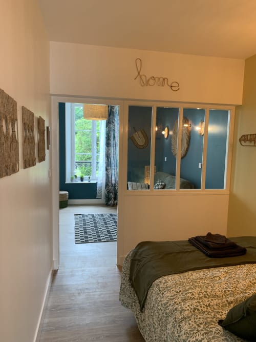 Bedroom suite at Les Remparts De Joussaume Latour in Château-Thierry with bed, sitting area, and garden views