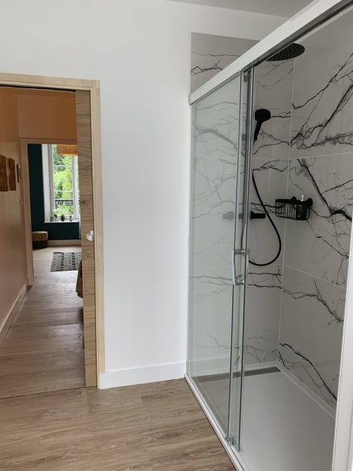 Modern shower enclosure with marble-effect tiles in Suite Le Renard et les raisins at Les Remparts De Joussaume Latour,