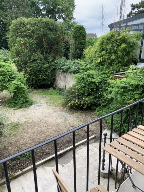 Lush garden view from Suite Le Renard et les raisins at Les Remparts De Joussaume Latour, Château-Thierry, featuring green