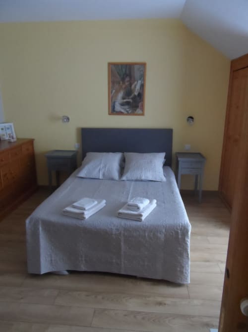 Chambre L'Anis à CafecouetBreizh B&B, vue jardin, lit queen-size, tête de lit sombre, literie blanche et mobilier en bois