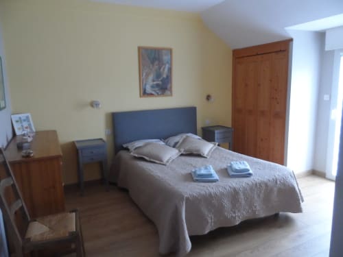 Chambre lumineuse au gîte CafecouetBreizh à Guipry-Messac avec lit double, mobilier en bois et vue sur le jardin depuis le balcon