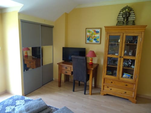La chambre Terracota du CafecouetBreizh B&B à Guipry-Messac avec murs jaunes, mobilier en bois, bureau TV et décoration égyptienne