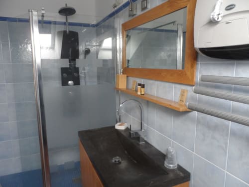 Salle de bain moderne de la chambre La Terracota à CafecouetBreizh B&B, Guipry-Messac, avec vasque noire, miroir encadré bois et