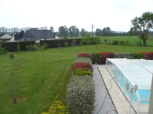 Vue luxuriante du jardin de CafecouetBreizh B&B à Guipry-Messac avec terrasse piscine, aménagement paysager et campagne